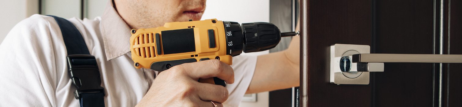 Atornillando el mecanismo de la cerradura de una puerta de entrada.