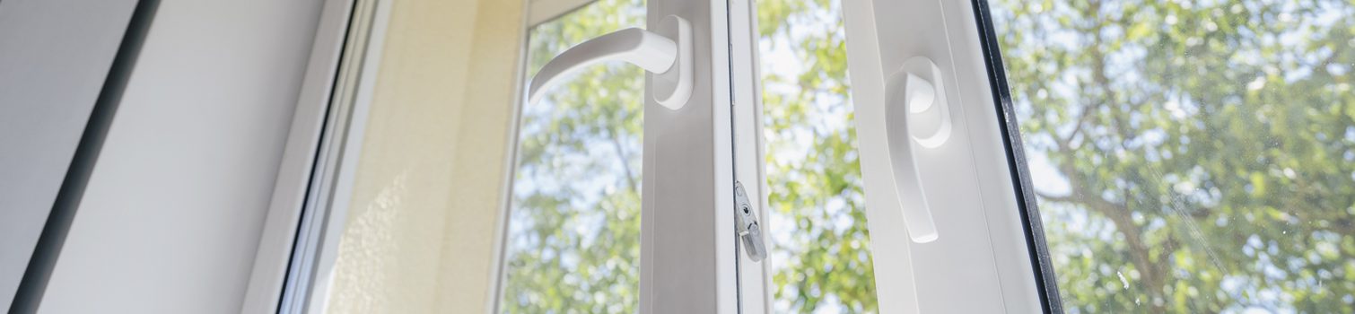 Primer plano de los pomos de una ventana abierta de aluminio.