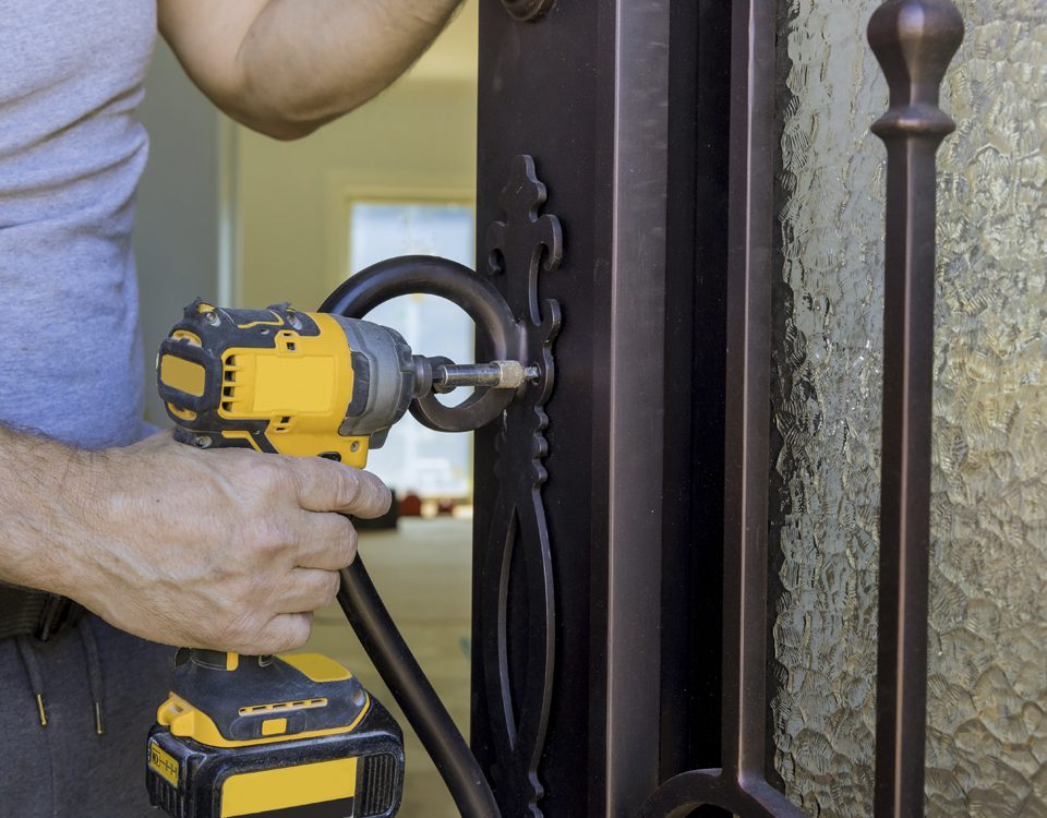 comunidades servicios I Un cerrajero instala una cerradura en el portal de una Comunidad de vecinos.