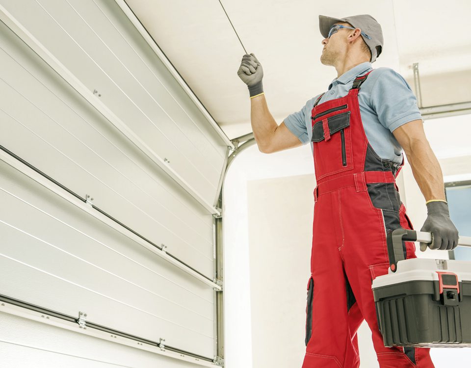 comunidades servicios II Un cerrajero revisa la puerta automática de la entrada de un garaje.