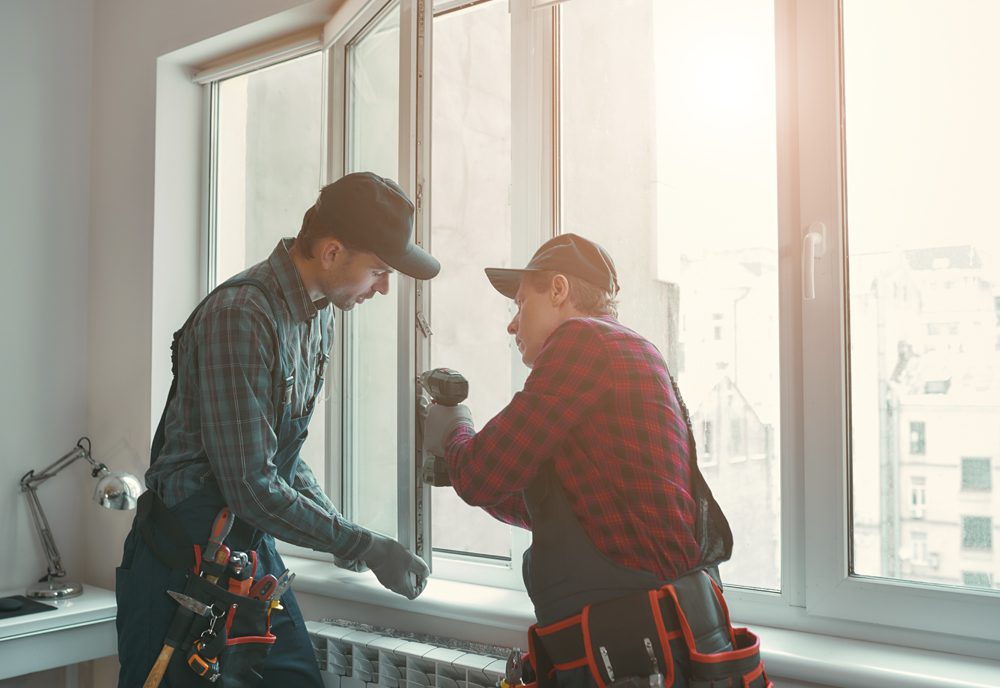 Servicio de ventanas y persianas motorizadas Dos cerrajeros ajustando una ventada que presentaba daños.