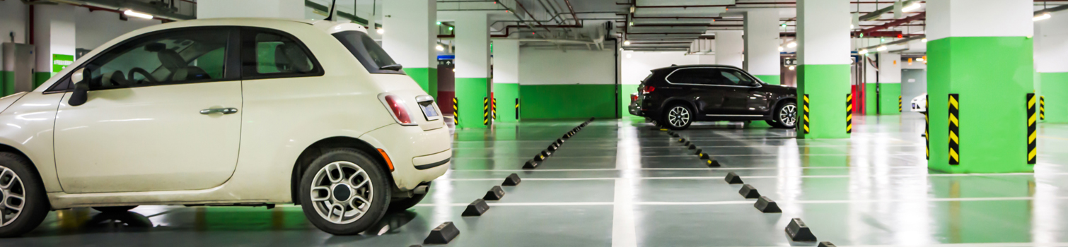 insights robos garaje interior Interior de un garaje comunitario con plazas de aparcamiento ocupadas por vehículos, un espacio que keys cerrajeros aconseja proteger para evitar robos.
